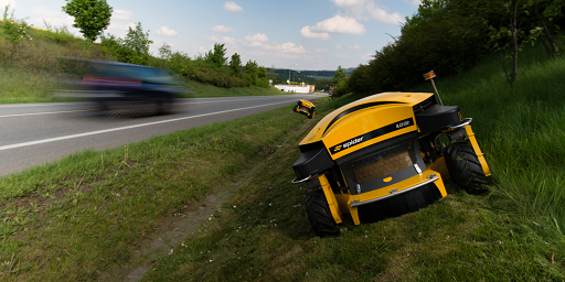 Spider mowers cutting grass next to a motorway